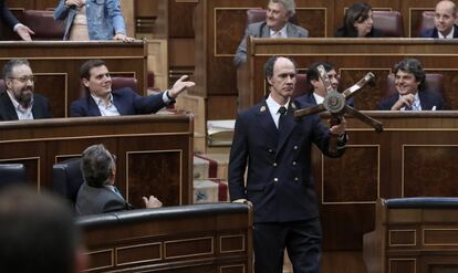 Un ujier retira parte del asiento roto del diputado de Ciudadanos Toni Roldan durante el Pleno en el Congreso de los Diputados.