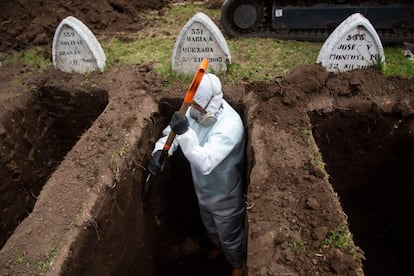 Un trabajador protegido con un equipo de bioseguridad cava tumbas para fallecidos por coronavirus, en el cementerio de San Diego, en el Centro Colonial de Quito (Ecuador).