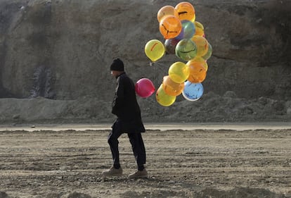 Un joven vendedor camina con globos de colores en Kabul, Afganistán.
