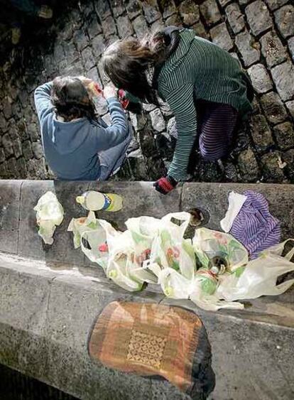 Dos jóvenes practican el <i>botellón</i> en una plaza de Vitoria.