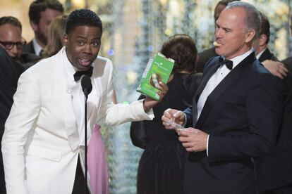 Chris Rock despide la gala mientras le observa comiendo galletas Michael Keaton, del reparto de 'Spotlight'