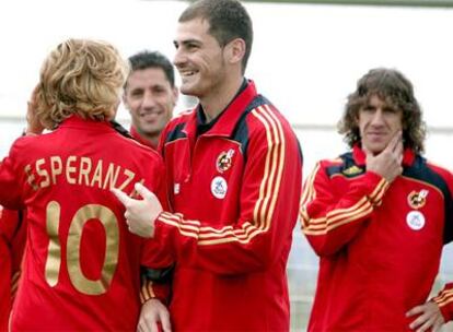 La presidenta de la Comunidad de Madrid, Esperanza Aguirre, con la camiseta de la selección, conversa con Casillas ante Capdevila y Puyol.