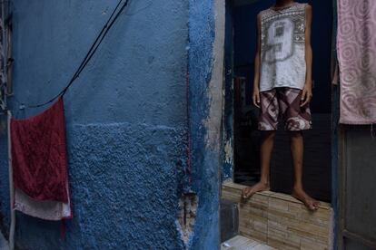 Un niño fotografiado en la entrada de su casa de la favela. Se observan las marcas de los disparos efectuados durante el operativo policial.