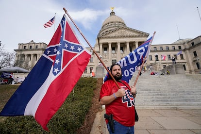 Un hombre porta una bandera antigua del Estado de Misisipi y otra de apoyo a Trump, el 6 de enero. 