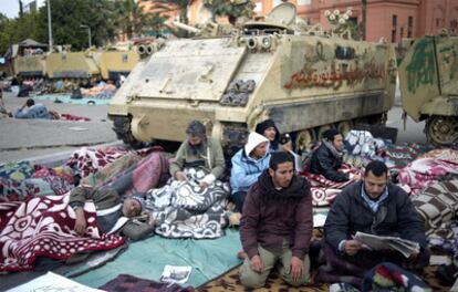 Manifestantes anti-Mubarak, junto a un blindado en la plaza de la Liberación de el Cairo.