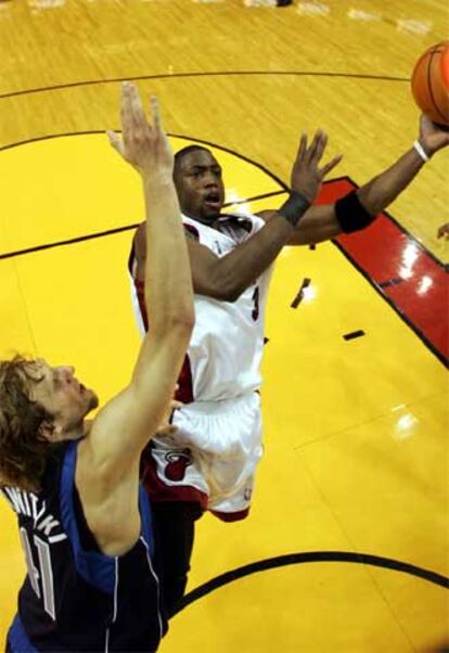 Dwyane Wade , jugador de los Heat de Miami, lucha por un balón con Dirk Nowitzki, de los Mavericks de Dallas