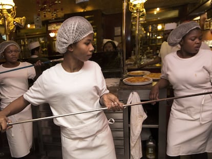 Tres migrantes reciben formación en un restaurante italiano.