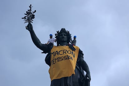 Un grupo de activistas colocan una pancarta en la estatua de la Plaza de la República durante las manifestaciones del Primero de Mayo.
