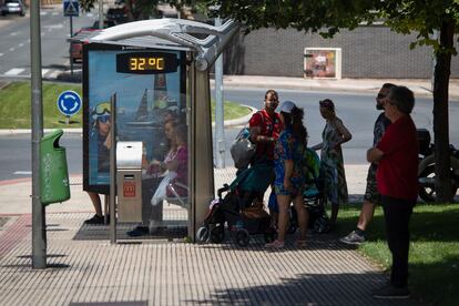 Personas esperan junto a una parada de autobús en Logroño.