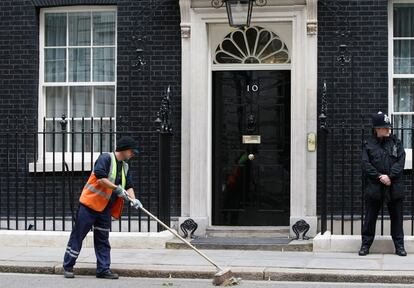 Un barrendero limpia la acera del 10 de Downing Street, residencia del Primer Ministro de Gran Bretaña.