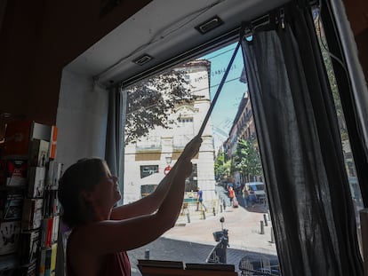 Una empleada de una librería de Madrid cierra las cortinas del escaparate, este martes.