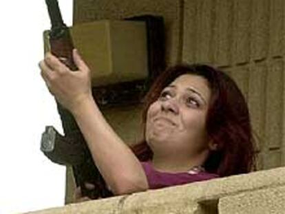 Una iraquí dispara su fusil al aire en Bagdad en señal de alegría por el resultado.
