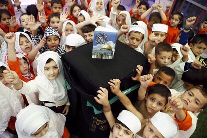 Niños sostienen un pilar que representa la "Kabaa" durante una clase sobre el 'Haj' o peregrinación a La Meca en un colegio en Hebrón (Palestina).