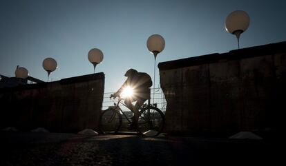 Un ciclista pasa junto a la instalación creada por el artista Christopher Bauder y que conmemora los 25 años de la caída del muro de Berlín. En éste caso los globos están junto a parte de la frontera levantada por la República Democrática Alemana que aún se conserva en la geografía de la ciudad.