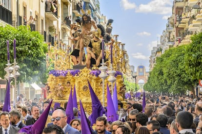El paso del Cristo de Las Cigarreras por la calle Asunción, con la Portada de la Feria de Abril al fondo, este Jueves Santo en Sevilla.