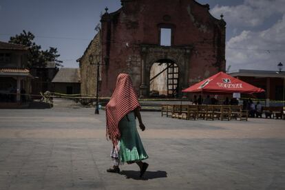 Una mujer camina por la plaza de Nurio, donde se ha improvisado un altar para recoger donaciones y proseguir con el culto ante la desaparicin de la iglesia del pueblo en un incendio que no se logr controlar. El templo ya haba ardido en tres ocasiones anteriores.