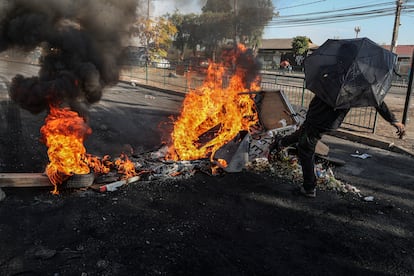Un manifestante patea los escombros de una barricada en llamas durante una protesta en en el barrio de Cerrillos en Santiago, el viernes 22 de mayo.