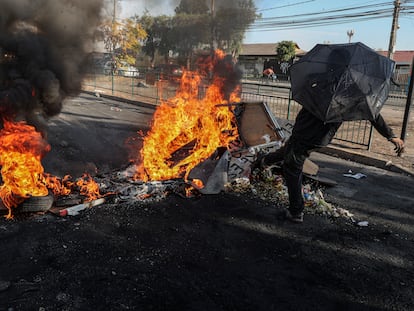 Un manifestante patea los escombros de una barricada en llamas durante una protesta en en el barrio de Cerrillos en Santiago, el viernes 22 de mayo.