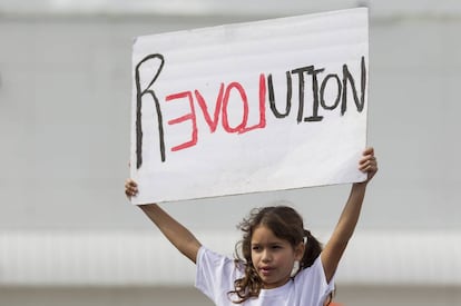 Menina segura cartaz na Marcha das Mulheres de 21 de janeiro.