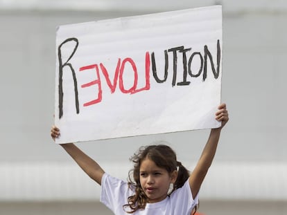 Menina segura cartaz na Marcha das Mulheres de 21 de janeiro.