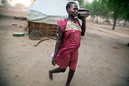 Terke Eda, embarazada de cuatro meses y madre de un niño, lleva una bandeja con comida durante una tormenta de arena en Dangaji. Sudán del Sur, que ya ha pasado por una ola de hambruna, tiene seis millones de habitantes (la mitad de la población) sufre inseguridad alimentaria, según la ONU. 