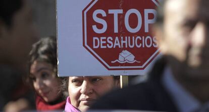 Una mujer sostiene un cartel contra los deshaucios en una manifestación.