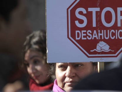 Una mujer sostiene un cartel contra los deshaucios en una manifestación.