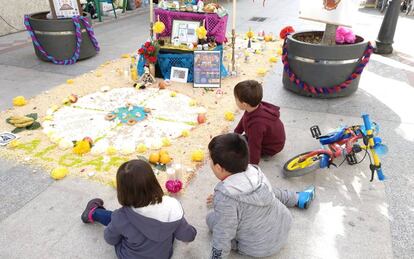 Tres niños observan el altar.