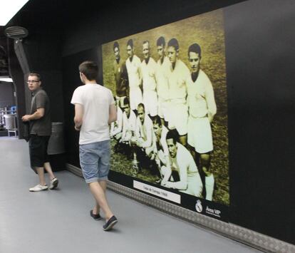 Los turistas ingleses Joe y David Starling junto a una foto de la final de la Copa de Europa de 1960, la quinta que logró el club. En la alineación de entonces, de izquierda a derecha: Domínguez, Marquitos, Santamaría, Pachín, Vidal, Zárraga (de pie); Canario, Del Sol, Di Stéfano, Puskas y Gento.