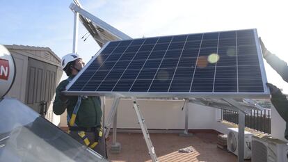 Un trabajador ajustando un panel solar.