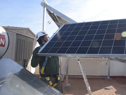 Un trabajador ajustando un panel solar.