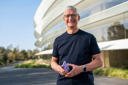 Apple CEO Tim Cook holds an iPhone 12 in a new purple finish