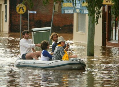 Varios habitantes del estado de Queensland abandonan sus casas en barca a causa de las graves inundaciones