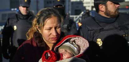 Cecilia sostiene a su hijo Dilan rodeada de agentes tras su desahucio.