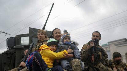 Militares ucranios con una familia tras la retirada rusa de Jersón.