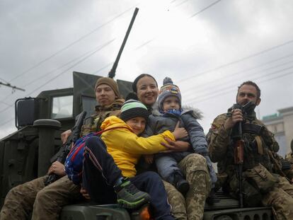Militares ucranios con una familia tras la retirada rusa de Jersón, el 16 de noviembre de 2022.