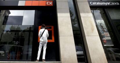 Una mujer utiliza un cajero autom&aacute;tico de Catalunyacaixa