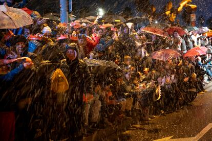 La gente se protege de la lluvia bajo sus paraguas, este viernes, durante la cabalgata celebrada en Barcelona. 