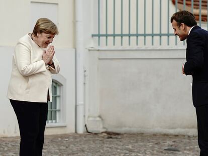 La canciller alemana, Angela Merkel, y el presidente francés, Emmanuel Macron, se saludan desde la distancia a las puertas del castillo de Meseberg, el lunes, al norte de Berlín.