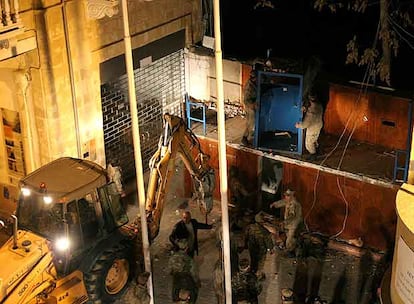 Un grupo de obreros trabaja con una excavadora en la demolición del muro en la calle de Ledra, en Nicosia.