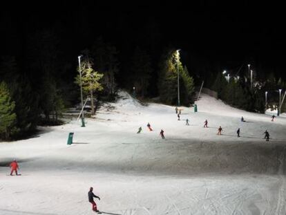 Esquiadors a l'estació de la Masella, il·luminada a la nit.