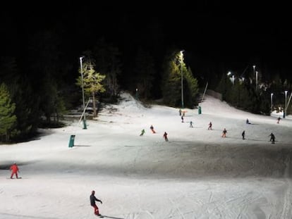 Esquiadores en la estación de La Masella, iluminada por la noche.