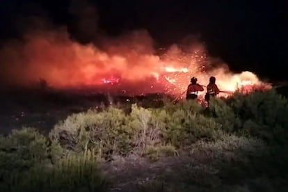 Los bomberos tratan de apagar el incendio en las cercanías de la localidad de Brañuelas, León, el lunes.
