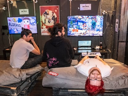 Tres jóvenes juegan a la videoconsola en el Meltdown bar, en el barrio de Chamberí.