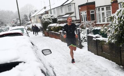 Un hombre corre por una calle nevada de Londres (Reino Unido).