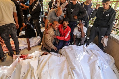 Varias personas lloran cerca de los cadáveres de las víctimas de los disparos del ejército israelí en el reparto de comida en Rafah, este martes en el hospital Nasser de Jan Yunis. 