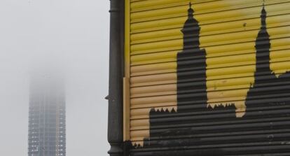 El rascacielos de C&eacute;sar Pelli, junto a la silueta de la Torre del Oro dibujada en un comercio de Sevilla.