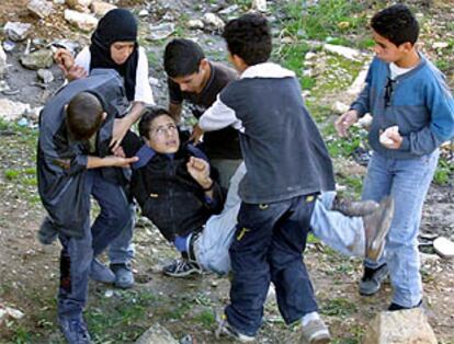 Varios niños evacuan a un amigo herido mientras lanzaban piedras contra soldados israelíes en Belén.