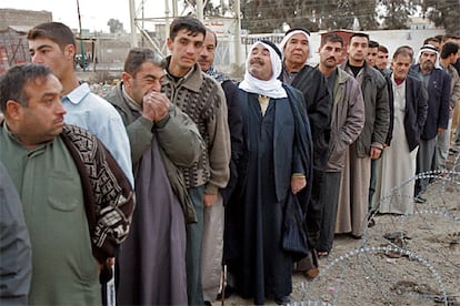 Un grupo de iraquíes hace cola ante un colegio electoral de Mosul. Se prevé una alta participación, aunque todo dependerá de si los suníes, minoritarios en el país, deciden finalmente acudir en masa a votar e integrarse en el proceso político en curso.