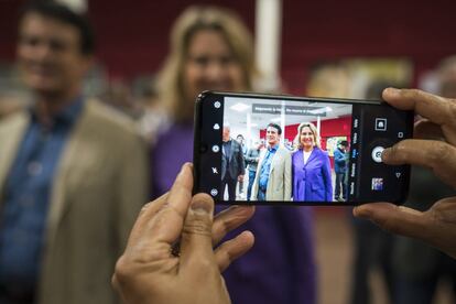 Un votante fotografía con el móvil a Manuel Valls, candidato de Ciudadanos a la alcaldía de Barcelona, junto a su mujer en el colegio Sant Miquel del Eixample, en Barcelona.